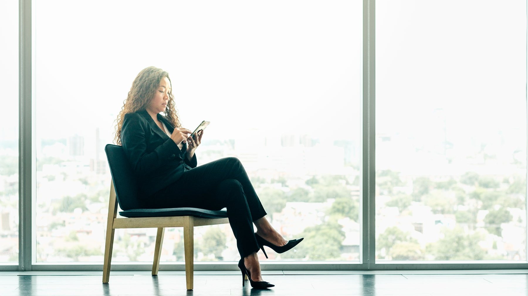 An advisor on a call beside tall office windows