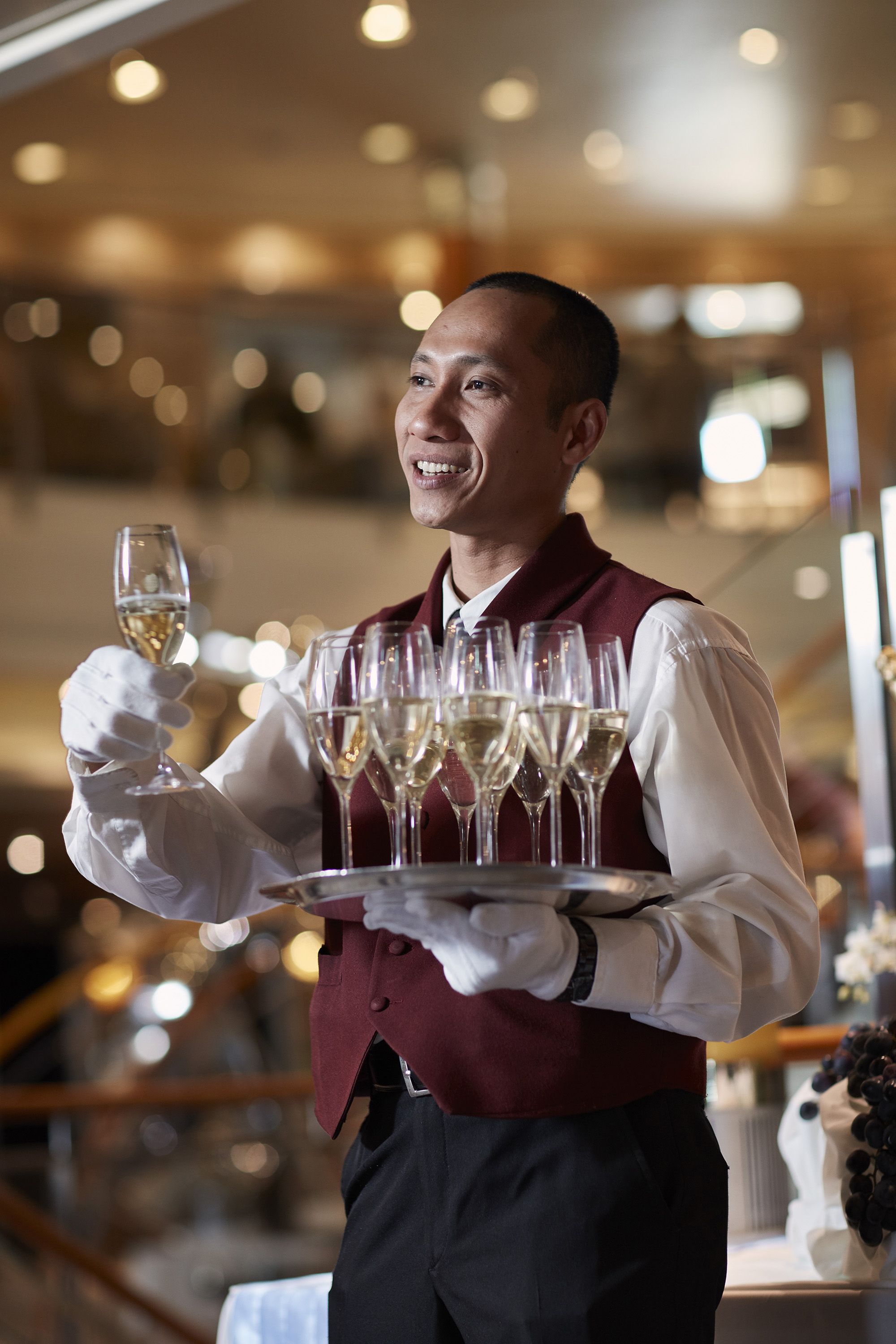 A host carrying a tray of champagne